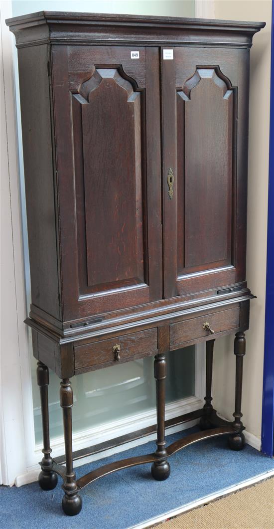 An early 18th century oak fielded panelled two door cupboard, raised on a stand W.87cm
